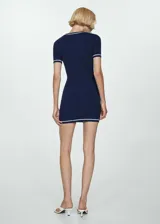 Vestido azul marino de punto ajustado al cuerpo, con cuello redondo y mangas cortas. Presenta ribetes blancos en cuello, mangas y ruedo.