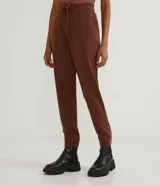 Pantalón jogger verde militar de algodón, con cintura elástica ajustable con cordón, bolsillos laterales y puños ajustados.