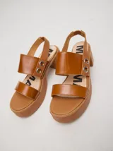 Sandalias negras de cuero con plataforma y taco ancho. Tienen correa trasera con elástico y doble argolla en la parte externa e interna.