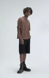 Remera de tejido de punto color café, con mangas cortas y cuello redondo. Presenta una textura calada y un calce ligeramente oversize.