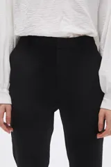 Pantalón negro de vestir, corte slim fit y largo al tobillo.