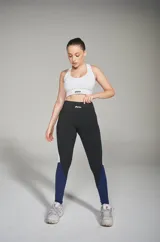 Calzas deportivas de diseño moderno, combinando negro y azul, con un ajuste ceñido al cuerpo.