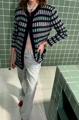 Cardigan vestido azul con rayas horizontales en tonos celeste, verde y beige. Tiene cuello redondo, mangas largas y cierre frontal con botones.