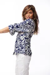 Blusa estampada azul y blanca con escote en V, mangas 3/4 con volados y cierre frontal con botones.