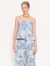Top celeste con estampado tie-dye, escote recto, breteles finos y corte peplum.