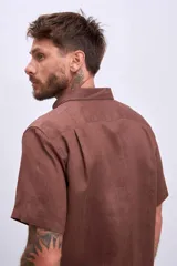 Camisa celeste de lino, de corte clásico, manga corta y cuello italiano.