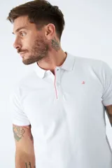 Polo blanco de manga corta con logo estampado y cierre parcial con botones. Corte regular.