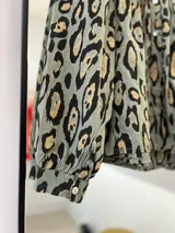 Camisa verde oliva con estampado animal print en tonos marrones y negros, cuello mao y mangas largas abullonadas.