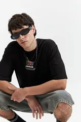 Remera negra de algodón con cuello redondo y estampado frontal con el logo de la marca Mistral y texto en blanco.