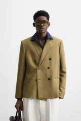 Blazer color marrón claro, de corte recto y doble botonadura. Confeccionado en tejido de lyocell y lino.