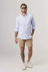 Camisa de hombre color crema, de corte clásico, con cuello abotonado y mangas largas.