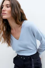 Sweater negro de tejido de punto fino, con escote en V y mangas largas.