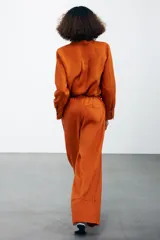 Pantalón palazzo color ladrillo confeccionado en lino 100%, de tiro medio con cintura ajustable con cordones, bolsillos laterales ocultos en costura y pierna ancha.