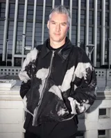 Campera bomber de jean color negro con estampado overo, cuello de cuero, puños de algodón y cierre frontal con cremallera.