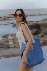 Traje de baño entero color blanco hueso, con textura gofrada o de punto en relieve. Presenta un escote recto y tirantes finos de color azul claro.