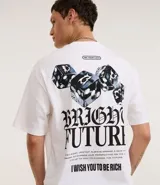 Remera de algodón blanca, corte relajado (relaxed fit), manga corta y cuello redondo. Presenta un estampado grande en la espalda con dados con diseño de calavera, el texto gótico "BRIGHT FUTURE" y la frase "I WISH YOU TO BE RICH". En la parte superior de la espalda tiene un pequeño texto en un recuadro que dice "TRY YOUR LUCK".