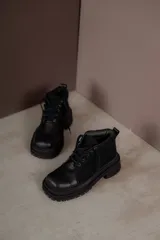 Borcegos negros de cuero con punta cuadrada, cordones y suela track.