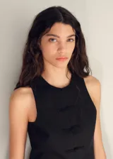 Vestido largo negro con chaleco incorporado, sin mangas y con abertura triangular en el abdomen.