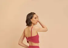 Top sin mangas de crep rosado con botones nacarados en la espalda y diseño ajustado.