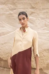 Túnica midi color beige con corte geométrico en lila y verde. Tiene cuello mao con botones y mangas 3/4.