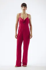 Mono largo negro de breteles finos, con escote cruzado y abertura en el abdomen. Pantalón de corte palazzo.