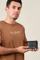 Billetera de cuero negro con franja decorativa marrón en el lateral. Diseño clásico con múltiples compartimentos para tarjetas y billetes.