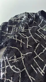 Minivestido negro con lentejuelas y estampado geométrico blanco.