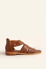 Sandalia de cuero color marrón chocolate, con suela plana y diseño calado con detalles trenzados.