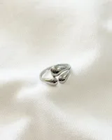 Anillo plateado de acero con diseño abierto y tres apliques en forma de gota.