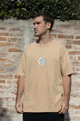 Remera color beige de manga corta con estampado circular en el pecho con diseño abstracto en blanco y gris.