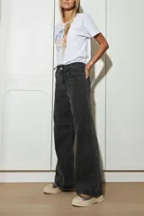 Remera blanca de algodón con cuello redondo y mangas cortas. Estampado frontal con un caballo azul, rosas rosadas y texto bordado en hilo amarillo.
