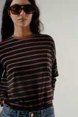 Camiseta de manga larga, corte holgado, con cuello redondo y estampado de rayas horizontales en tonos negro y marrón.