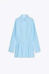 Vestido corto camisero celeste de algodón, con cuello solapa, manga larga con puños plisados, detalle de tablas en la falda y cierre frontal con botones.