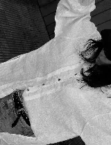 Camisa blanca oversize de lino con corte estilizado, tablas visibles en el frente y canesú con alforzas en la espalda. Manga larga abullonada con puños altos. Cierre frontal con botones.