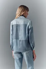 Camisa celeste de tencel con diseño patchwork y lentejuelas transparentes bordadas. Tiene calce recto, cuello camisero y botones metálicos.