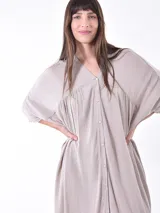 Vestido color naranja, corte irregular, con cuello en V y botones frontales.