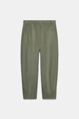 Pantalón capri color verde militar confeccionado en lino, de tiro medio, con bolsillos laterales y traseros. Cierre frontal con cremallera y botón.