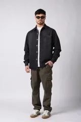 Chaqueta de jean celeste de corte recto, con cuello clásico, cierre frontal con botones metálicos y bolsillo de parche en el pecho.