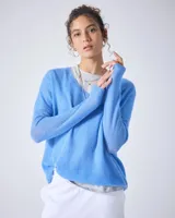 Suéter celeste de cashmere con cuello en V, corte oversize, mangas largas, hombros caídos y acabados acanalados.
