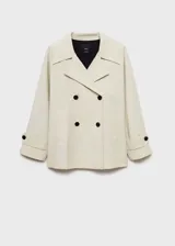 Anorak color beige con cuello de pico con solapa, manga larga con trabillas, cierre de doble botonadura y dos bolsillos laterales.