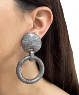 Aros colgantes con un diseño moderno y elegante. Cuentan con un ajuste de clip y están hechos de resina.