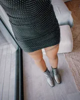 Botín de cuero color marrón con caña media, punta fina y taco geométrico de 10 cm.