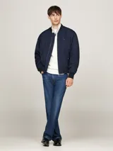 Campera bomber azul marino Tommy Hilfiger, con cuello, puños y bajo de punto canalé. Cierre frontal con cremallera, dos bolsillos laterales con botón a presión y logo bordado en el pecho.