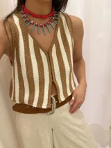 Chaleco de punto con rayas verticales color beige y blanco, con cierre frontal de botones.