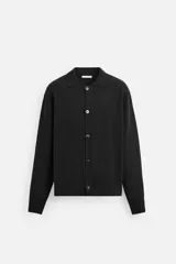 Camisa de punto color negro, corte relaxed fit, con cuello solapa, manga larga y cierre frontal con botones.
