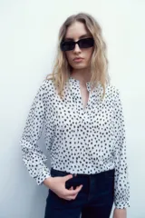 Blusa de manga larga con cuello mao y estampado floral en blanco y negro.