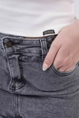 Minifalda de jean color gris oscuro desgastado, tiro medio/bajo, con cierre y botón frontal.