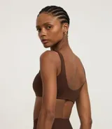 Top deportivo de microfibra color fucsia, con tirantes anchos fijos y copa incorporada.