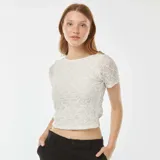 Camiseta blanca de encaje con mangas cortas y espalda abierta.