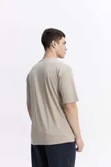 Remera lisa color beige de corte oversize, con escote redondo y mangas cortas.